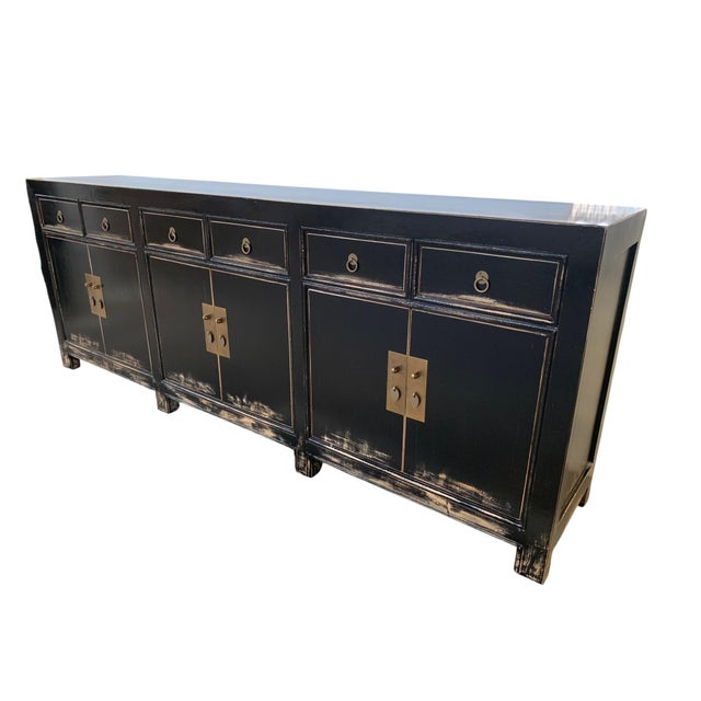 This sideboard is newly made from solid pine wood with a distressed black lacquer finish and weathered rub-through edges....