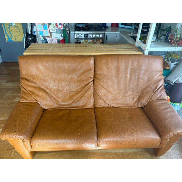 Two-seat Durlet leather loveseat in caramel/tan with adjustable headrests. Approx. 68" W x 37" D x 36" H. Durlet is a...