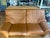 Two-seat Durlet leather loveseat in caramel/tan with adjustable headrests. Approx. 68" W x 37" D x 36" H. Durlet is a...