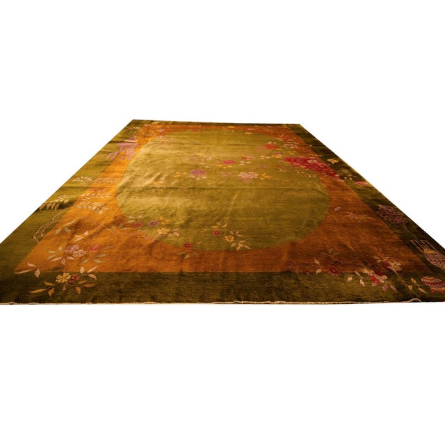 This circa 1920, 11' x 15' 7" Antique Chinese Art Deco rug a striking solid green ground and matching border,...