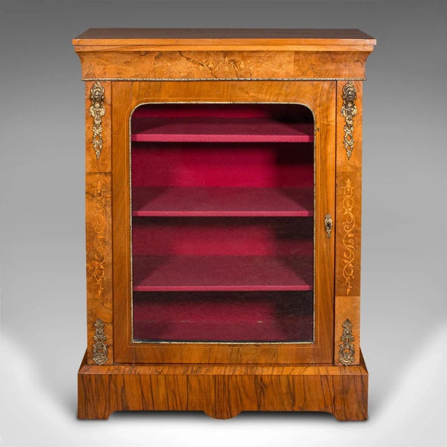 This is an antique pier cabinet. An English, walnut and boxwood glazed bookcase or display cupboard, dating to the Regency...