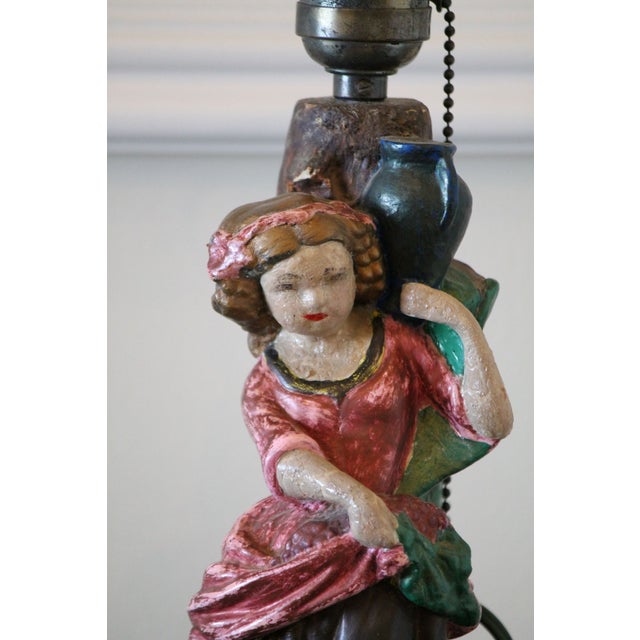 Colorful antique chalkware lamp from the 1930s of a lady carrying a pot. Original cord and pull chain. No major condition...
