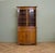 A well-made 1930s oak display cabinet in the Georgian Revival style, featuring a serpentine front, curved cornice,...