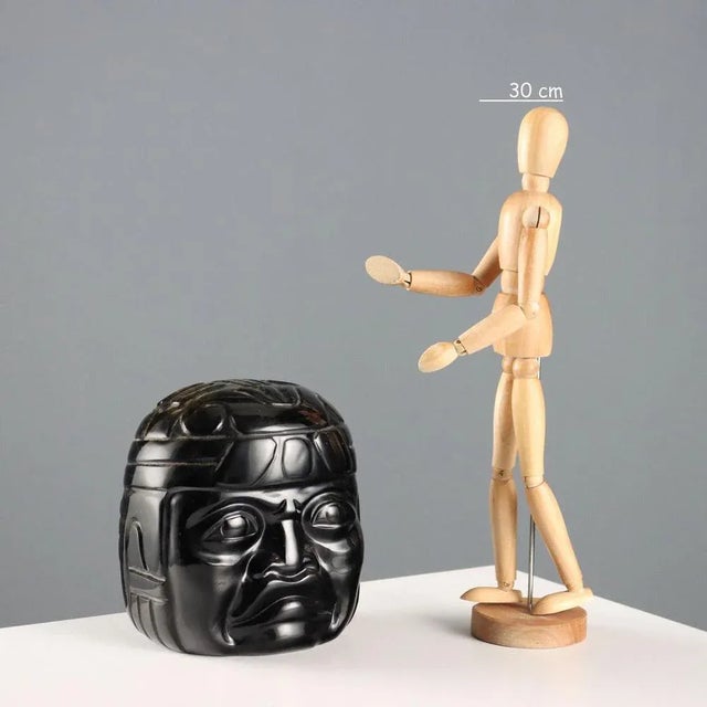 Obsidian stone sculpture depicting a head, reproduction of the colossal works produced by the Olmec civilization. This...