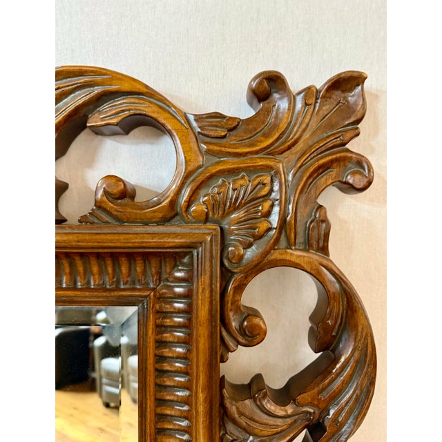 Ornately carved and generously scaled, this wood mirror adds warmth, drama, and classic elegance to any room. Its deep...