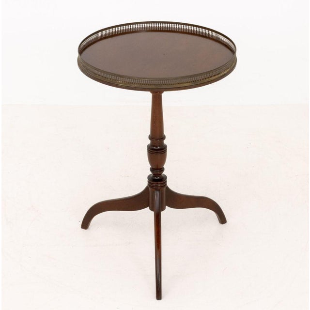 Schott Furniture Mahogany Circular Tripod Table, with brass galleried top on three spider legs, marked to underside. 27" H...