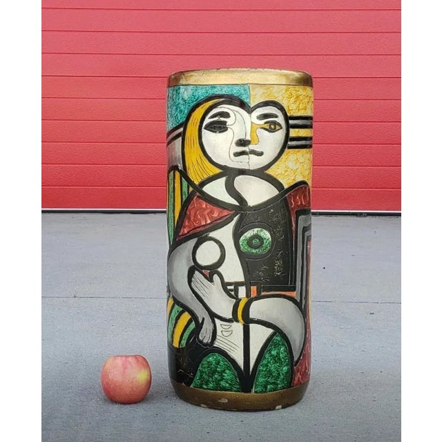 A unique and colorful ceramic umbrella stand that is reminiscent of Picasso's style and imagery. It's definitely a piece...