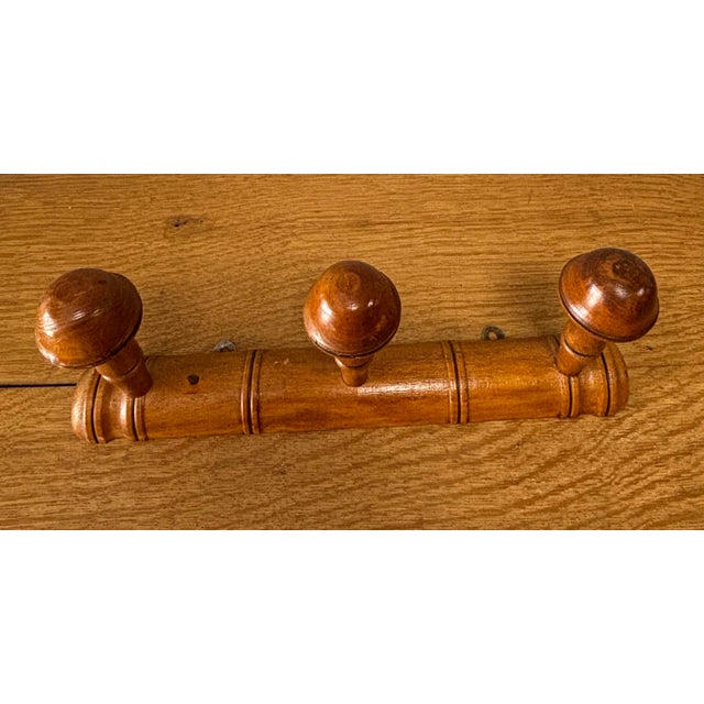 A charming vintage French wooden coat rack crafted in the classic faux bamboo style, a design long favored for its...