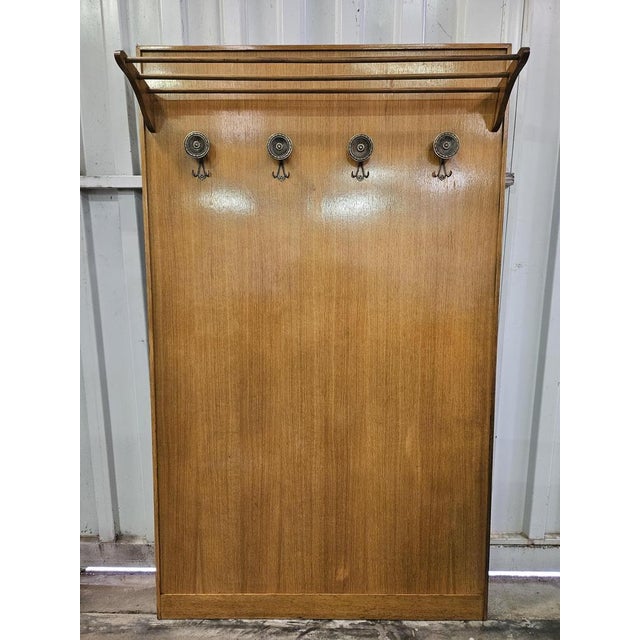 Large wall coat hanger entirely made of wood with four worked and decorated brass hangers. The piece of furniture is...