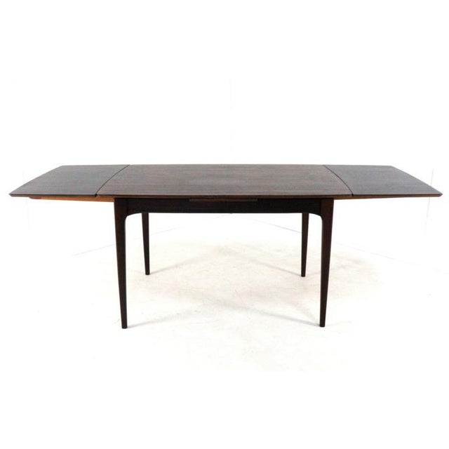 Extendable dining table with a luxurious rosewood finish. This beautiful dining table is in a used but very serviceable...
