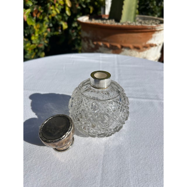 Vintage sterling silver and cut crystal bottle featuring a beautifully faceted spherical crystal body and a polished...