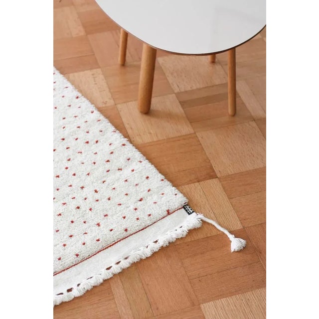 Hand woven wool carpet. Undyed ivory wool with naturally dyed orange wool.