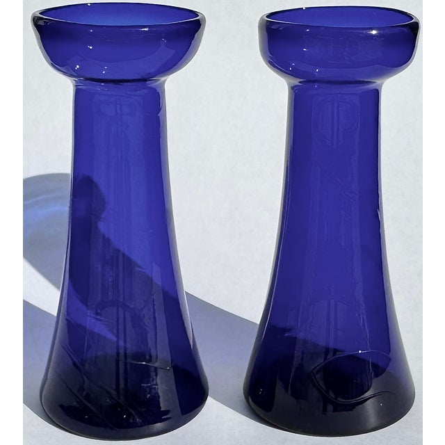 A beautiful pair of antique hand-blown cobalt bulb forcing glasses, their gently swirling bodies and visible pontil marks...