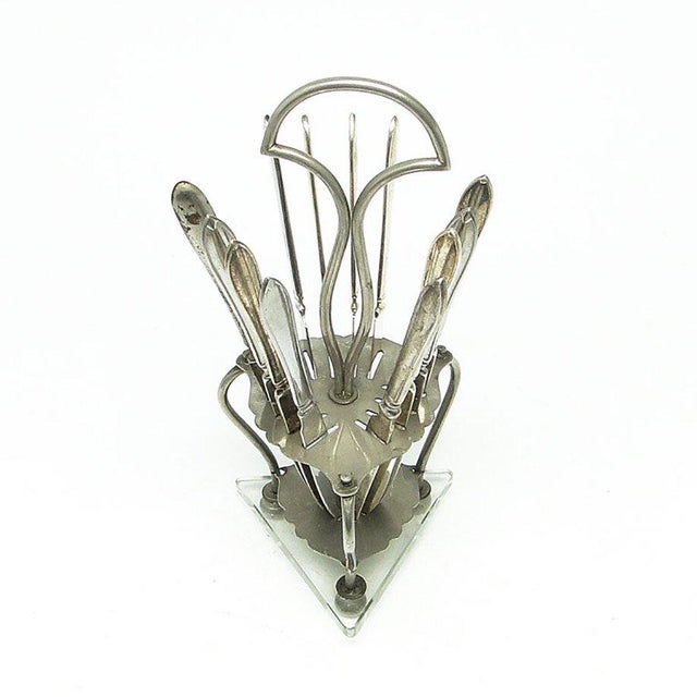 The stand with fruit scissors was produced in Germany in the 30s. The surface is made of clad brass on a faceted glass...