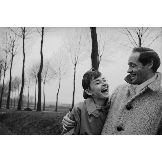 Hepburn And Ferrer American actor Mel Ferrer (1917 - 2008) buttons up his coat around his wife, actress Audrey Hepburn...