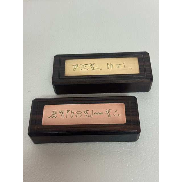 Set of 2 antique dark walnut paperweights with brass and copper plates engraved with Egyptian hieroglyphics. Green felt...
