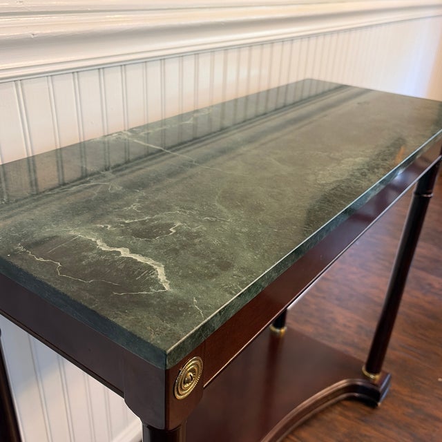 Bombay Co. Neoclassical inspired empire style foyer console table. Features a green marble top, Mahogany wood with brass...