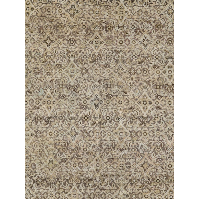An antique Persian Malayer rug from the early 20th century. The slate and brown field is very closely covered by a...
