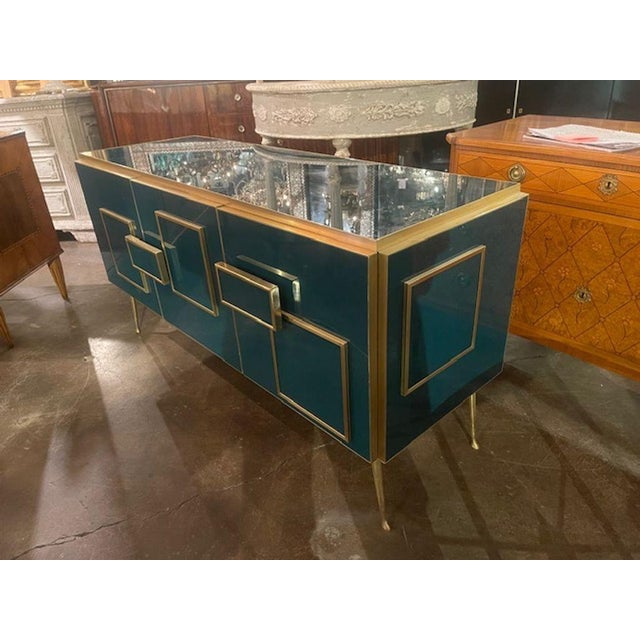 The Modern Murano Glass and Brass Cabinet in Peacock Plume Green is a stylish and elegant piece of furniture .The...