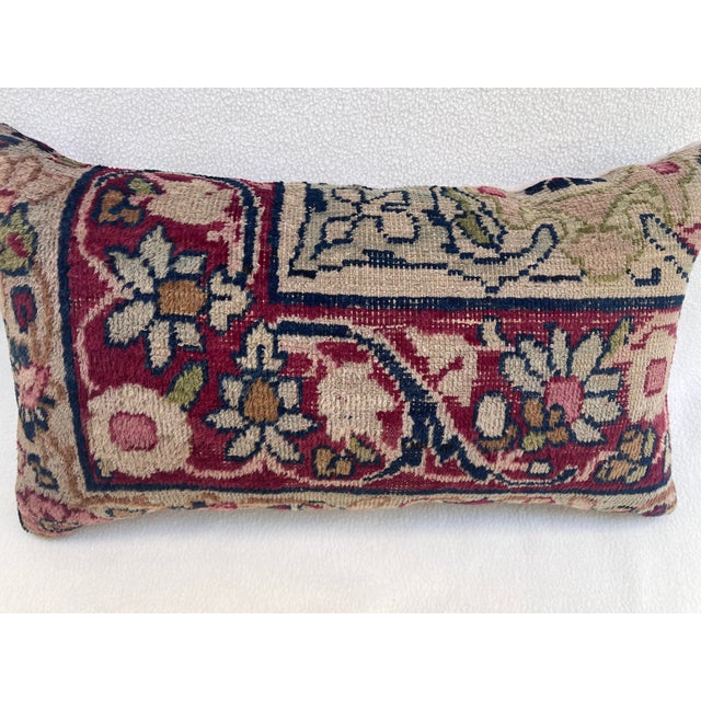 Decorative pillow upholstered in a 19th century Kerman rug fragment, featuring charming floral flowerhead motifs and an...