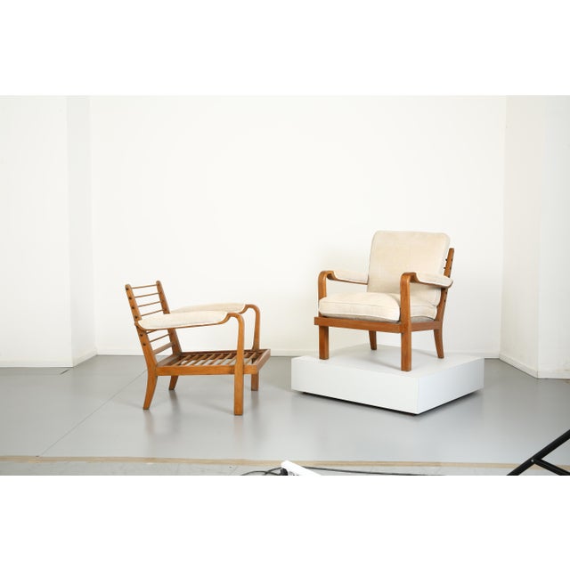 The two "La Riposante" armchairs are made of oak with velvet-covered cushions. A spring tension rod is missing. Some...