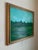 A richly colored landscape painting featuring layered hues of green and blue, softly accented with touches of yellow that...