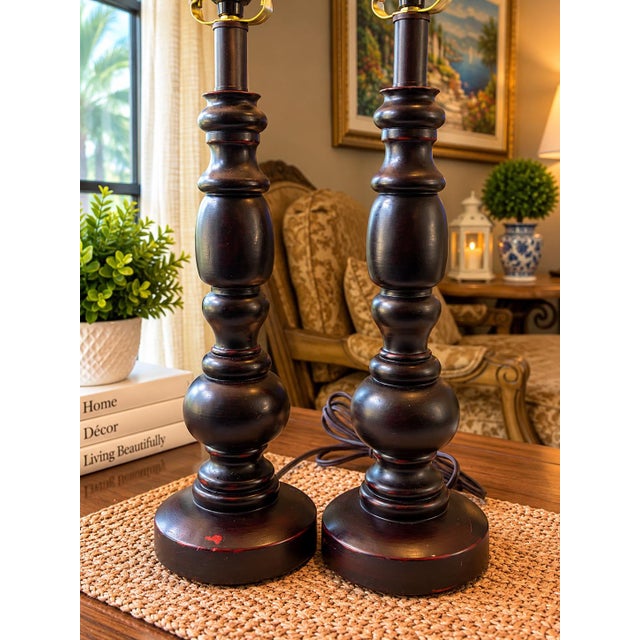 Elegant pair of tall table lamps with a traditional turned wood-look design and rich dark finish. The beautifully shaped...