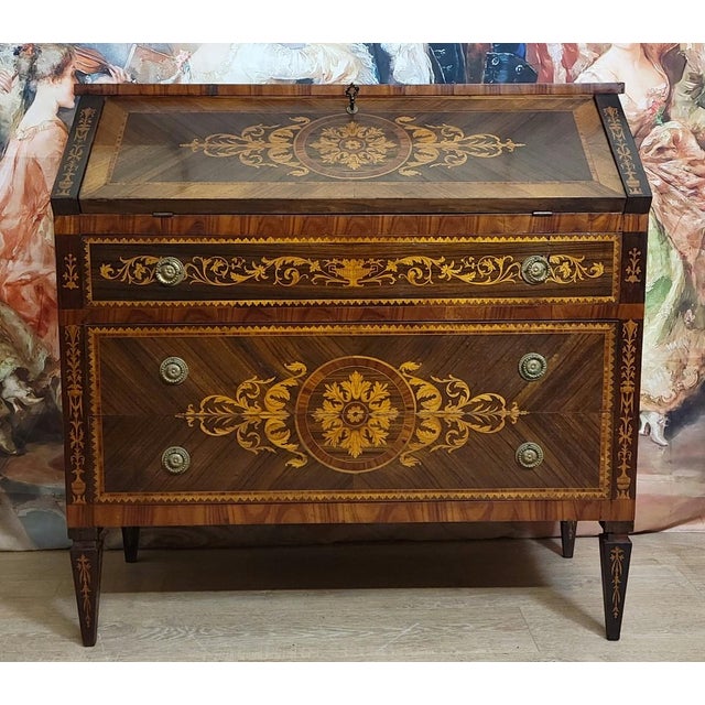 A louis xvi style drop-front secretary desk, crafted from richly inlaid precious woods, featuring a refined decoration of...