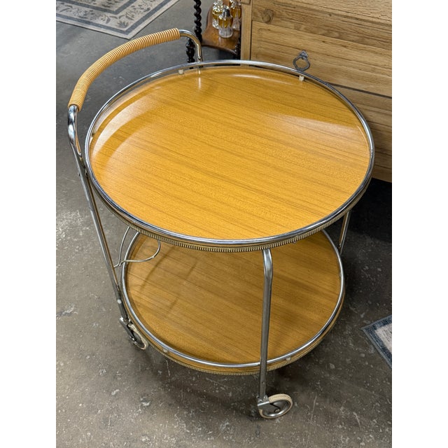 A beautifully designed vintage French bar cart, showcasing the effortless elegance of mid-century modern design. This two-...