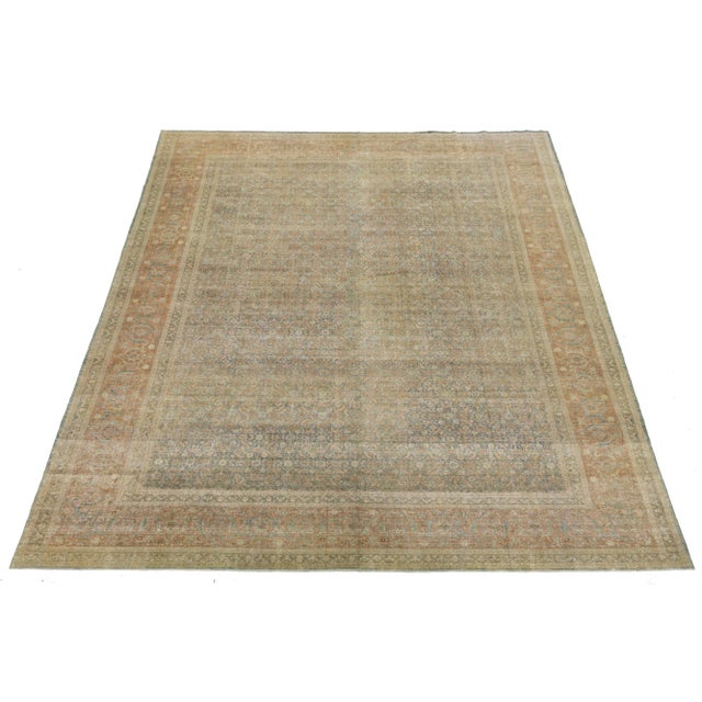 Early 1900s handknotted Persian Tabriz rug in soft walnut, sand, faded terracotta, and slate blue. Features dense floral...