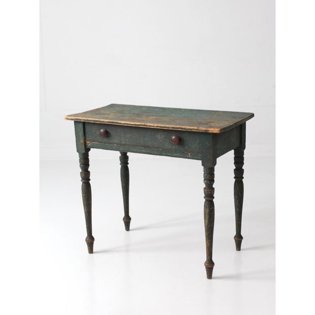 A 19th-century American country table with early Federal influence, featuring a beautifully worn green painted surface...
