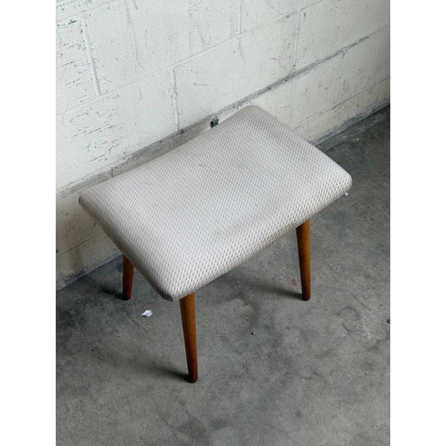 Vintage Danish Mid Century Modern vanity stool featuring solid teak tapered legs and a softly curved upholstered seat....