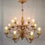Chandelier with 12 arms of light. Iron scrolls with leafy stems in cut sheet metal gilded with the leaf. Lighting with...