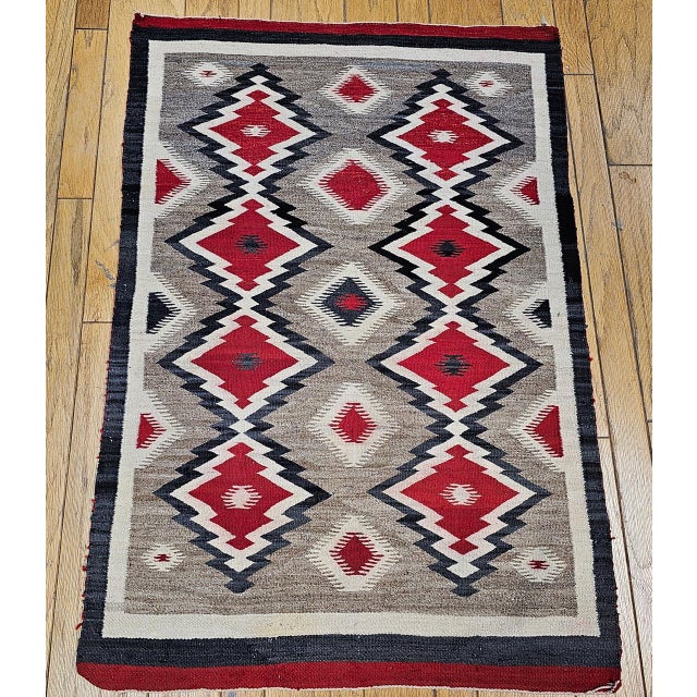 A dynamic and visually captivating example of traditional Navajo textile art, this early 20th-century Eye Dazzler rug is...
