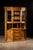 Large-scale oak hutch constructed in three distinct sections, combining display cabinetry, a central serving surface, and...