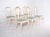 Six wooden chairs painted white. This set of six chairs displays a classic, romantic style influenced by French design....