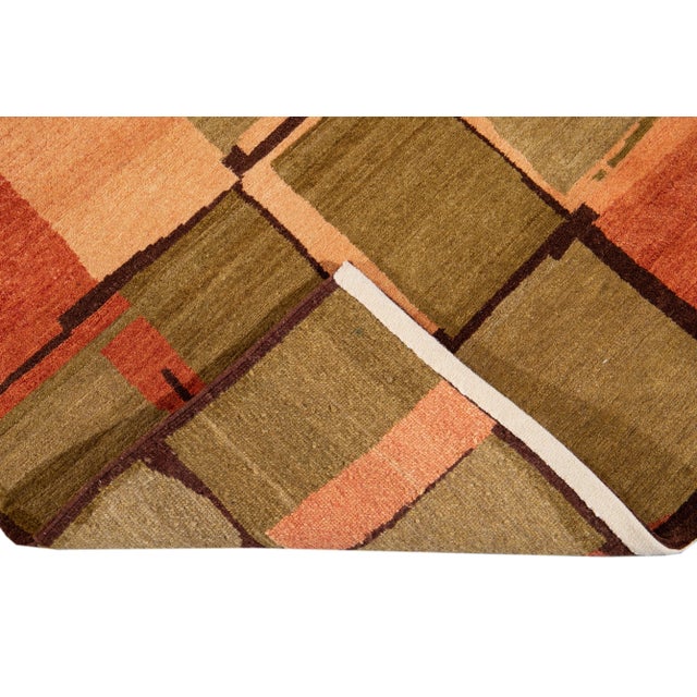 This contemporary Tibetan rug is expertly crafted by hand using wool and silk and boasts a striking green and orange color...