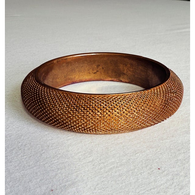 Vintage mid-century Brutalist bangle bracelet featuring a wide, domed profile covered in dense woven mesh with a repeating...