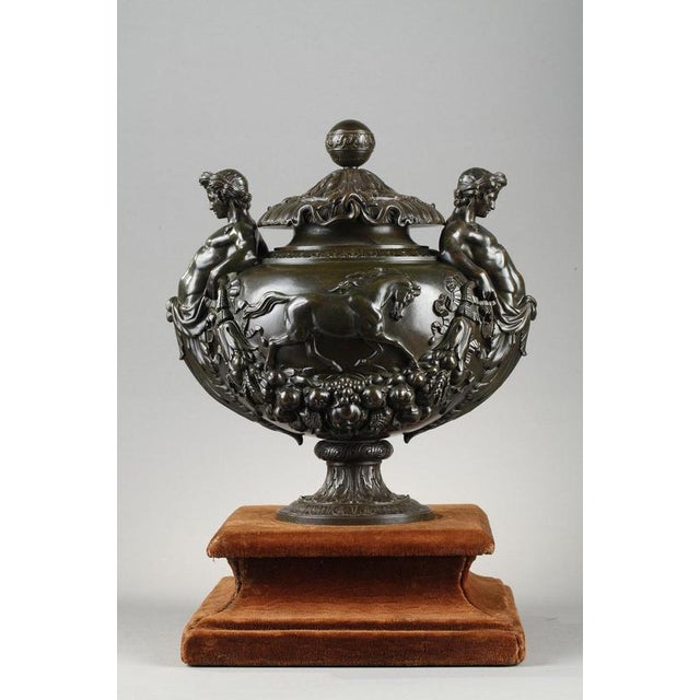 A patinated bronze pedestal urn with a ball-shaped lid decorated with acanthus leaves, ovals and entwined snakes. On the...