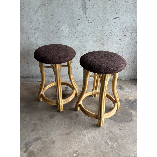 This elegant pair of vintage counter-height stools is executed in the manner of McGuire, showcasing sculptural rattan...
