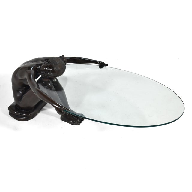 This dramatic coffee table has terrific presence in any room. The base is a bronze sculpture of a nude woman who sits,...