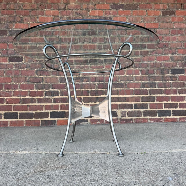 This unique metal dining set features four metal frame upholstered chairs, a matching metal table base and circular glass...