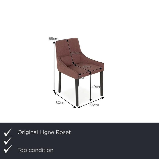 The Long Island chair set from ligne roset is covered in red fabric and stands on brown wooden feet. It is characterized...
