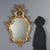 Giltwood mirror, crafted in Barocchetto style, originating from 20th century Italy. The frame features an elaborate...