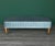 This Mid-Century bench is newly upholstered in a turquoise pleaded satin textile and supported by walnut tapered legs....