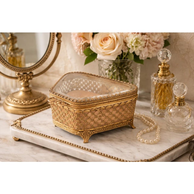 This elegant vintage jewelry box features a beautifully detailed gilt metal (ormolu-style) body with an intricate floral...