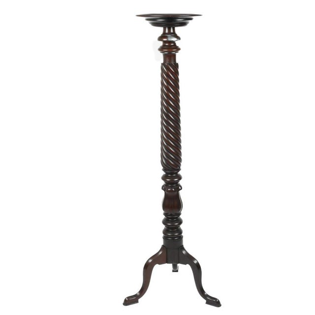 A Chippendale Style Carved Mahogany Plant Stand features intricate spiral carvings on the legs or central column, creating...