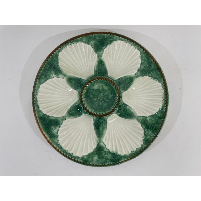 A beautiful classic French Longchamp glazed majolica oyster plate with a vibrant green faux basket weave background and...