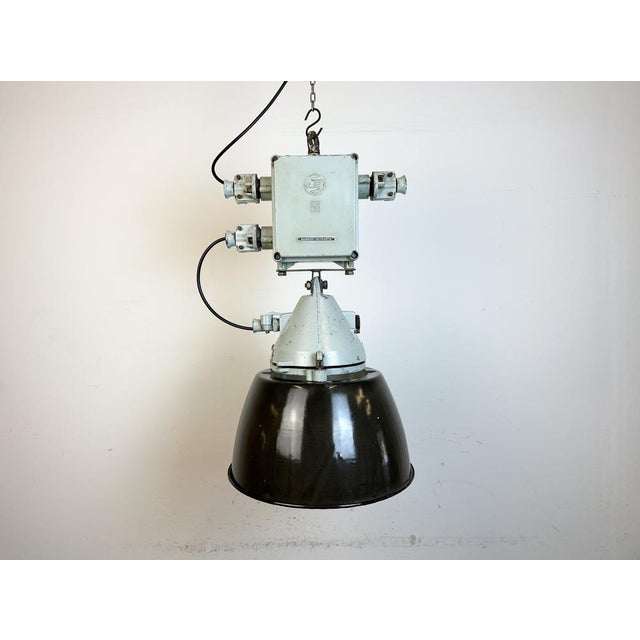 Grey industrial lamp with massive protective glass bulb made by Elektrosvit in former Czechoslovakia during the 1970s.It...