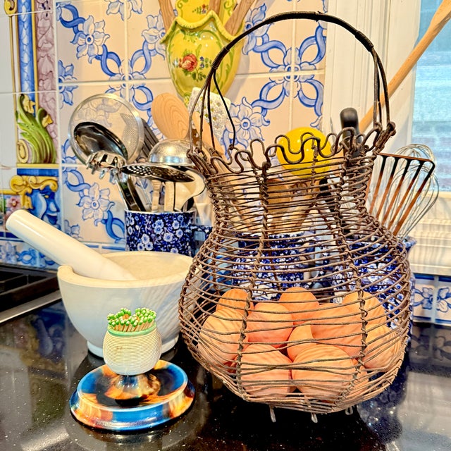 From France, a hand-made Fil de Fer, iron wire egg basket, circa 1890 – 1910. A petal top footed basket made of twisted...